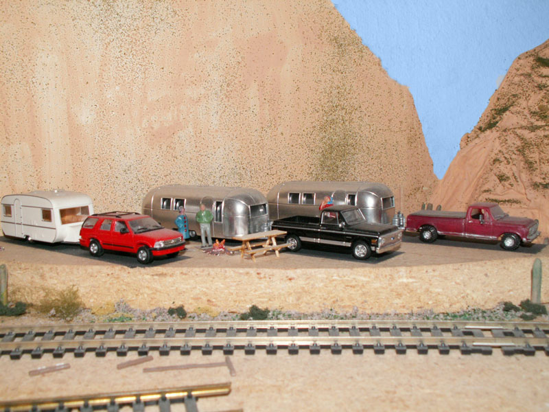 A pair of Air Stream trailers share the campground with a modern trailer