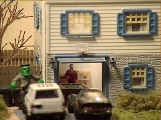 A corvette and a SUV are in the driveway